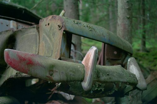 Valokuva auton romusta metsässä